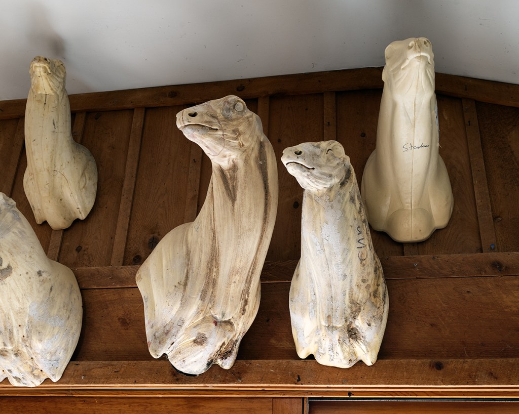 Natural Causes photograph of worn foam taxidermy animal forms arranged along a wall.