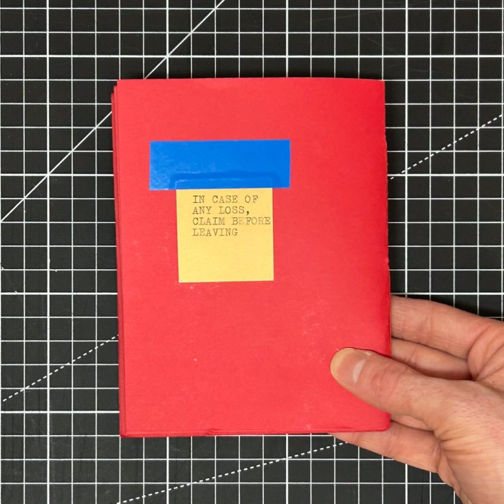 Back cover of Is This Your Coat? with a yellow coat-check ticket attached with blue electrical tape.
