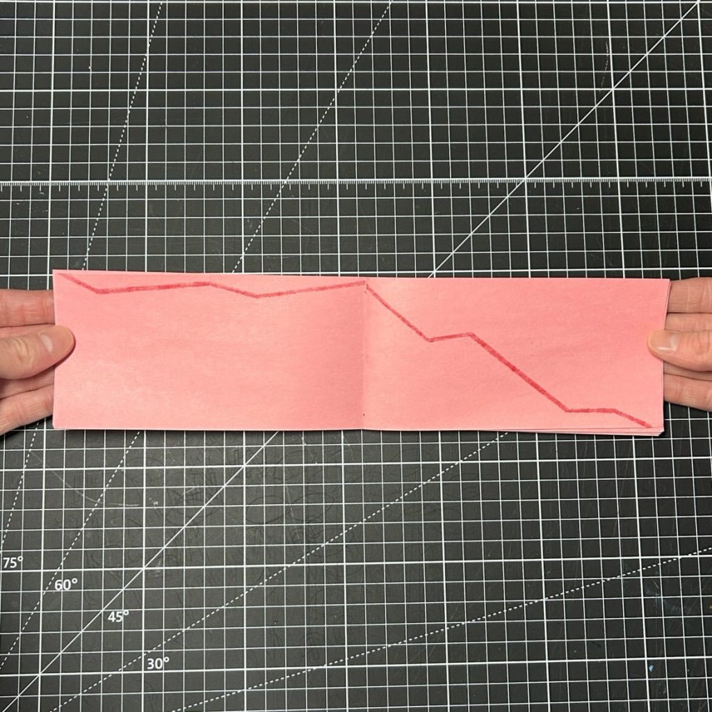 Open pink spread from The Beginning of the Rest of Your Life with a red hand-stamped line graph descending across both pages.